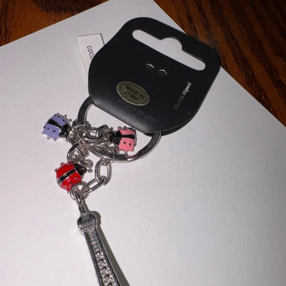 NWT PARIS EIFFEL TOWER KEY CHAIN WITH LADY BUG CHARMS. LOOK AT PICS OF TOWER